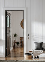 Farmhouse style entryway.  Doorway, bench, pillow, hardwood floors.